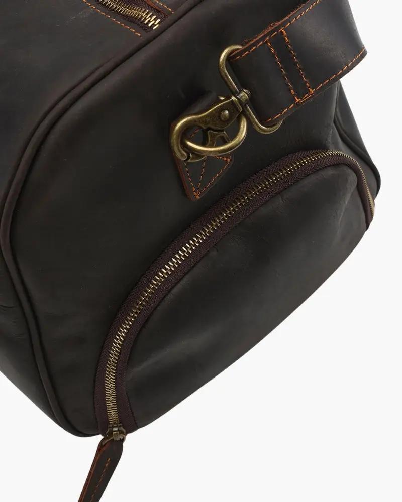 Sac de voyage en cuir marron Old Money Montague Duffle avec poignées robustes et fermeture à glissière visible.