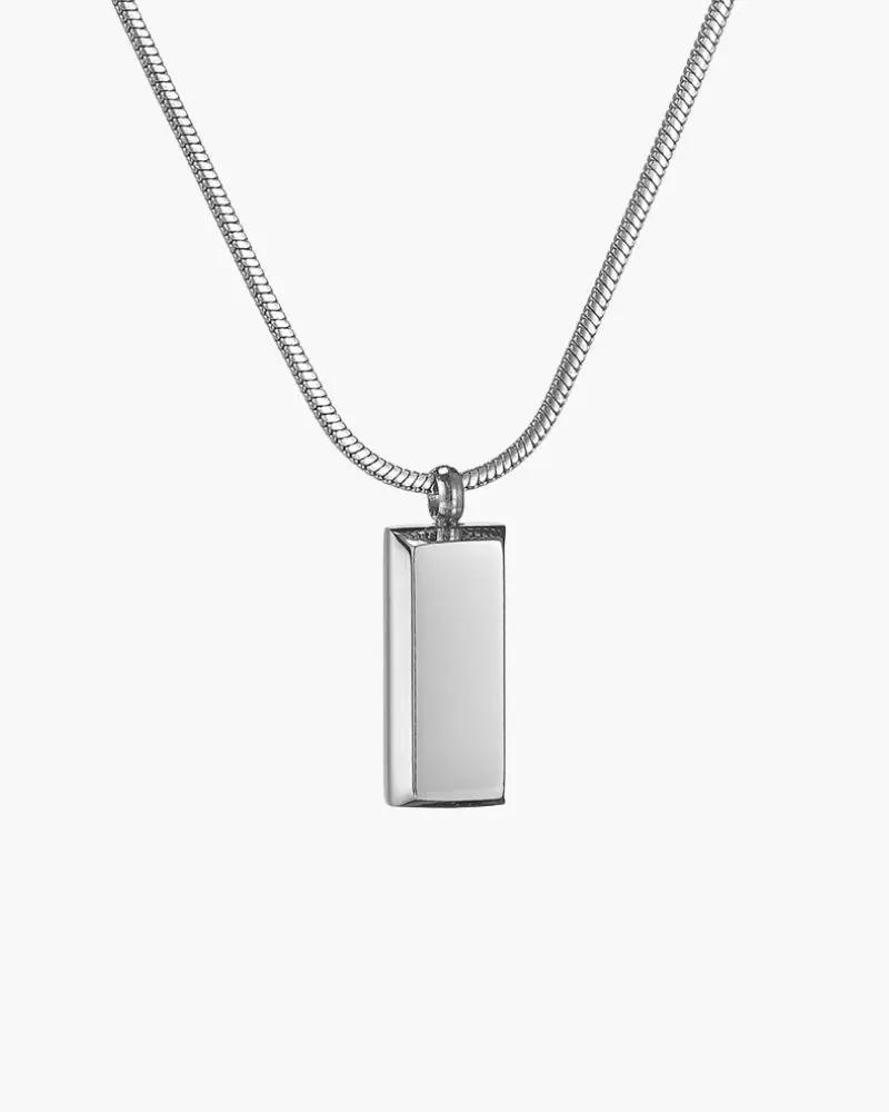 Pendentif Axis Tag de la marque Old Money avec un design élégant en or, posé sur un fond neutre.