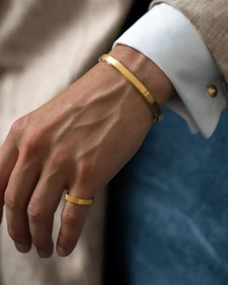 Bracelet orné de laiton doré de la marque Old Money, avec un design épuré et élégant, porté sur le poignet.