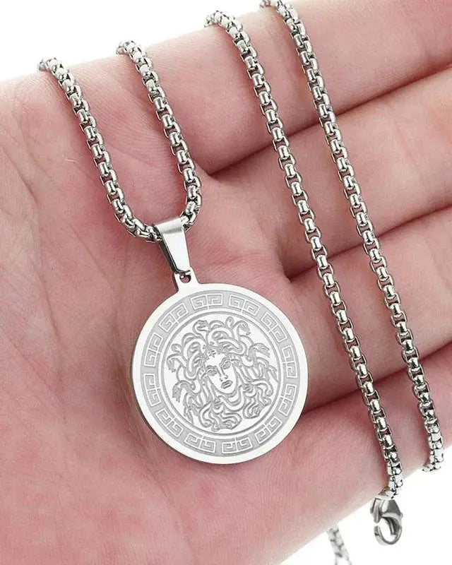 Chaîne longue Medusa en or et argent de la marque Old Money, détail de la pendentif Medusa en métal précieux.