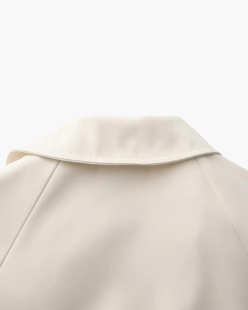 Manteau trench beige Heritage de Old Money Women, coupe classique, porté en extérieur, vue de face.