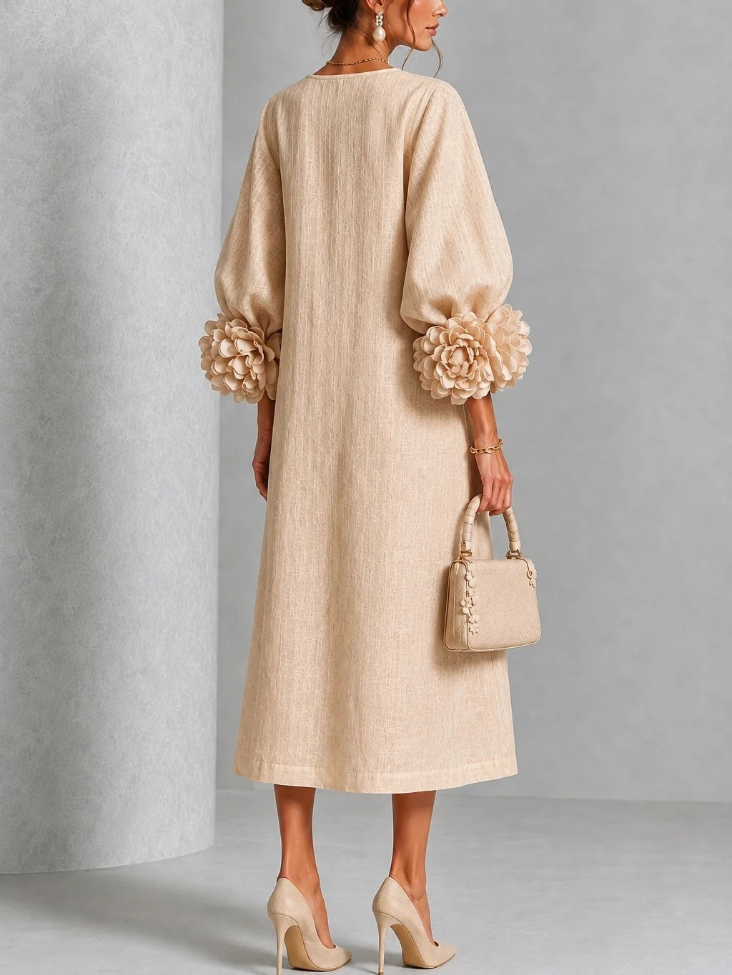 Robe à rosettes 3D Hydra™ de Danoir Paris, tissu léger avec motifs en relief, portée avec manches longues et décolleté élégant.