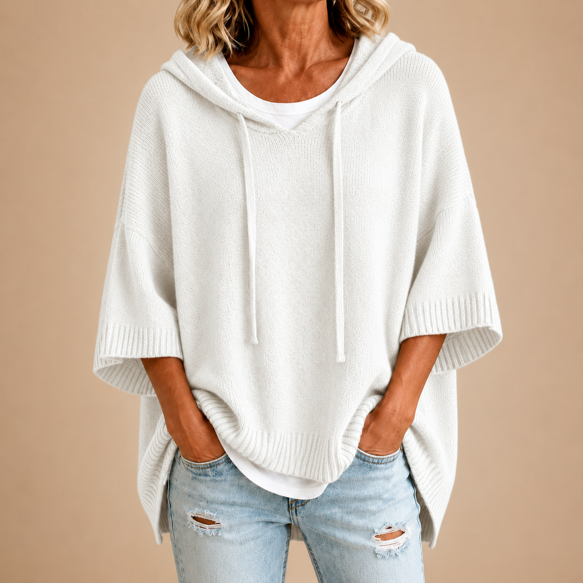 Poncho en maille blanc avec capuche de la marque Danoir Paris, doux et confortable pour un style décontracté.